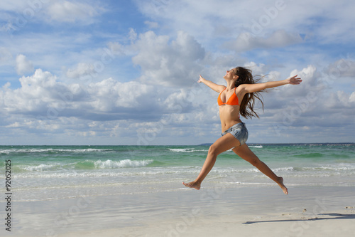 Fotografía Happy woman jumping on the beach on holidays