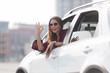 Beautiful lady showing okay sign from her car