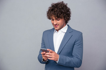 Wall Mural - Portrait of a happy businessman using smartphone
