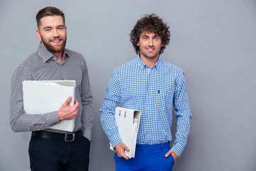 Wall Mural - Portrait of a two casual businessmen holding folders