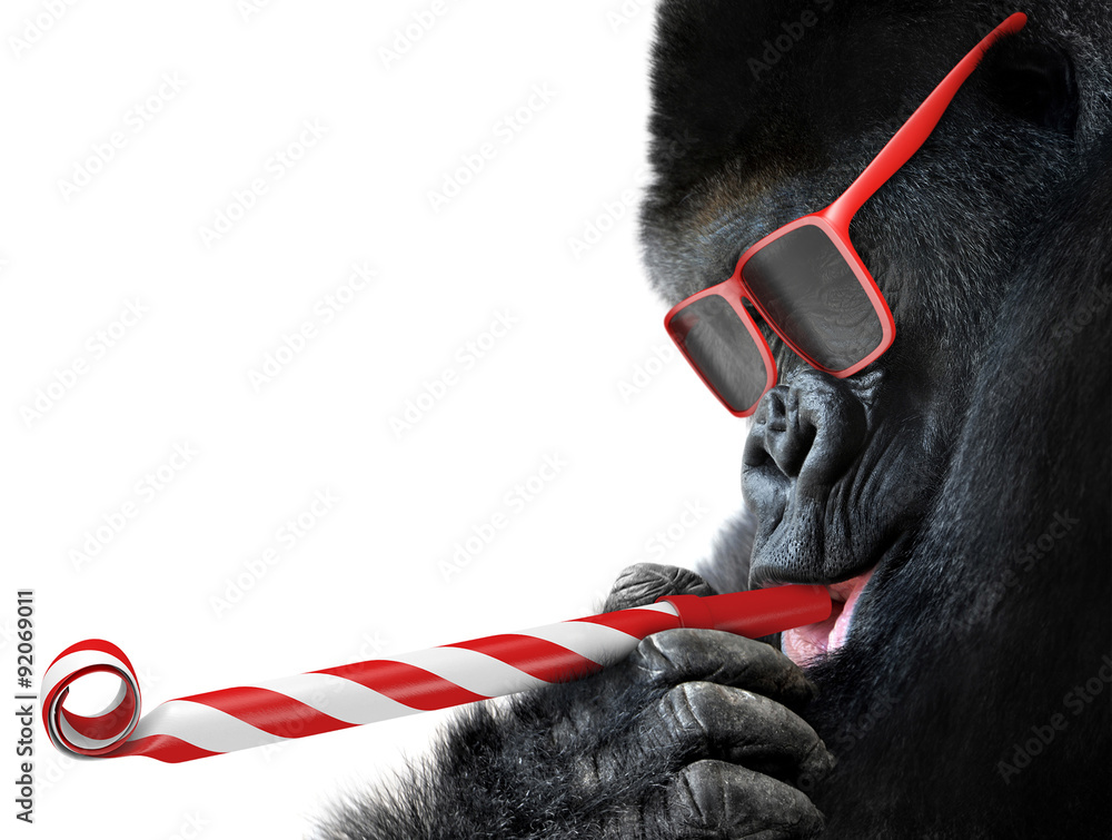 Funny gorilla with red sunglasses celebrating a party by blowing a striped horn - obrazy, fototapety, plakaty 