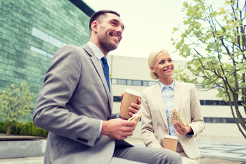 Canvas Print - smiling businessmen with paper cups outdoors