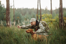 Yang Hunter With Rifle And Dog In Forest