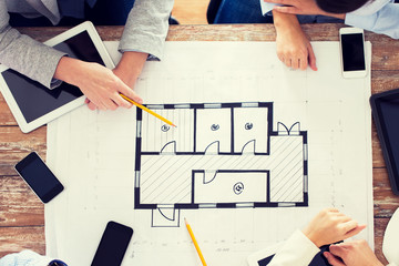 business team with blueprint and gadgets