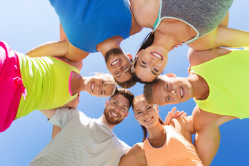 group of happy sporty friends in circle outdoors