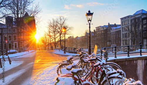 Zdjęcie XXL Wschód słońca nad kanałem ulice Amsterdamu, Holandia, z rowerami pokryte śniegiem w piękny zimowy dzień. HDR