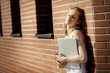 © MichelUlman - Beautiful student with laptop relaxing outside library.