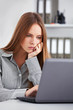© Dmytro Panchenko - Bored young business woman working with laptop.