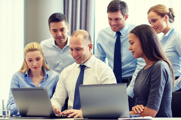 Poster - smiling businesspeople with laptops in office