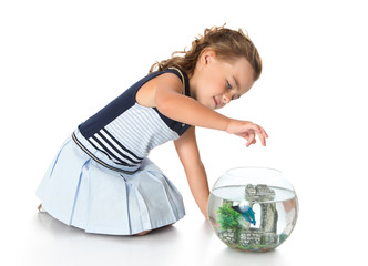 Girl is watching fish in an aquarium