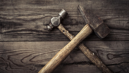 Old retro hammers on wooden workbench