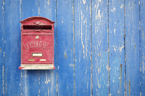 Fotografía Red mailbox with blue wood background