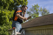 Contractor On Ladder Figuring Hail Damage Reairs To Roof