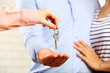 © Africa Studio - Real estate agent giving keys to young couple