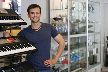 Wall Mural - Handsome young man in music store