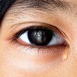 Closeup crying little asian girl looking her fighting parents in her eyes