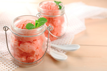 Wall Mural - Watermelon ice cream in glass jars  on color wooden background