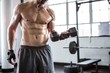 © Wavebreak Media - Fit man lifting heavy black dumbbell