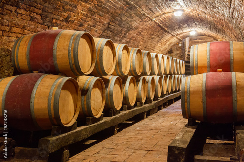 Oak barrels in a underground wine cellar Canvas Print