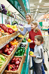 Mother and children with bell pepper in supermarket