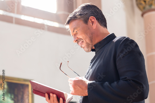 Fotomural Sacerdote católico Biblia de la lectura en la iglesia