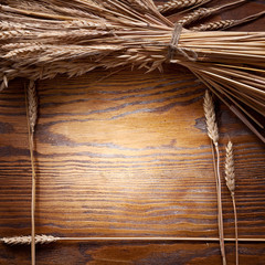 Canvas Print - Ears of wheat on old wooden table.