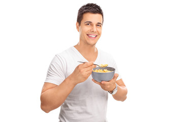 Poster - Cheerful young man eating cereal from a bowl