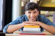 © Rido - Young man leans on stack of books