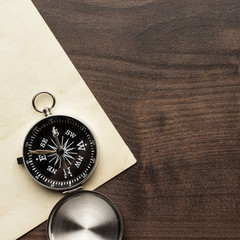 compass and old paper on the brown wooden table