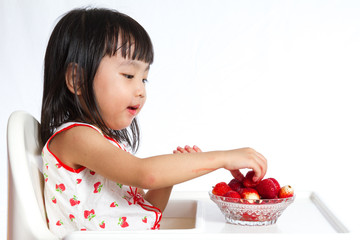 Wall Mural - Asian Chinese little girl eating strawberries