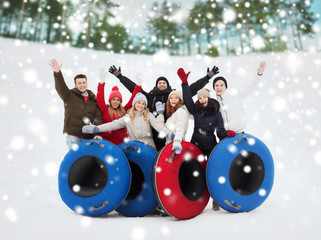 Wall Mural - group of smiling friends with snow tubes