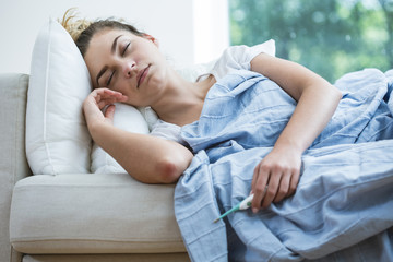 Wall Mural - Feverish woman lying under blanket