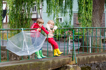 Wall Mural - Two little kid boys with big umbrella outdoors