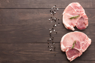 Top view raw pork chop steak and salt, pepper on wooden backgrou