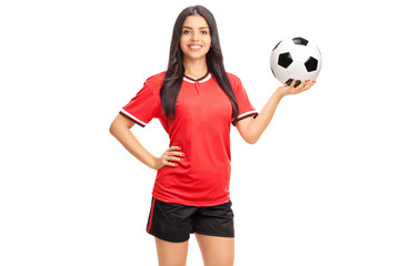 Wall Mural - Female soccer player in red jersey holding a ball