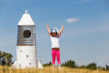 Wall Mural - Happy child dressed in an astronaut costume playing with hand ma