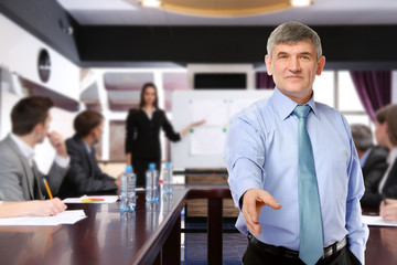 Wall Mural - Businessman giving his hand for a handshake and business people