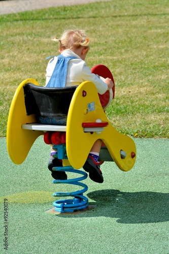 Fotografia, Obraz Une fillette joue sur un jeu mobile dans un parc