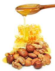 Wall Mural - nuts and honey dripping isolated on a white background