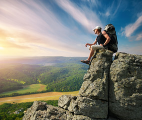 Man tourist on peak of mountain. Conceptual and travel composition.