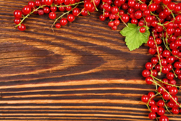 Poster - Red currant on wooden background.