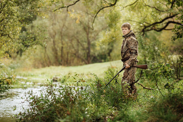 Wall Mural - hunter in camouflage clothes ready to hunt with hunting rifle