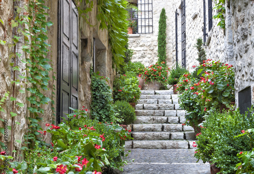 Naklejka na szybę grey stone steps between flower terracotta pots outside an old stone building