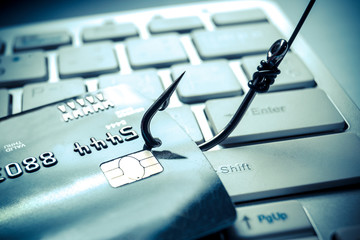 Wall Mural - credit card phishing - piles of credit cards with a fish hook on computer keyboard