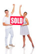 © michaeljung - excited young couple holding sold sign