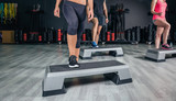 People legs over steppers training in aerobic class