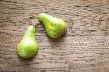 Wall Mural - Halves of green pear on the wooden background