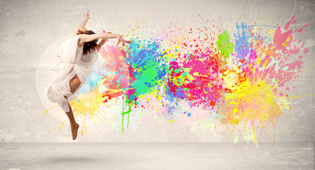 Wall Mural - Happy teenager jumping with colorful ink splatter on urban backg