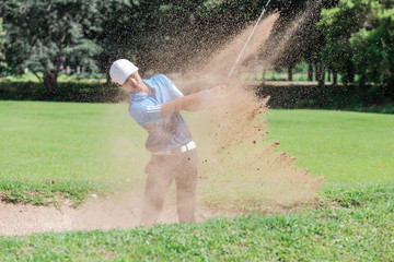 Yong asian golfer explosion sand.