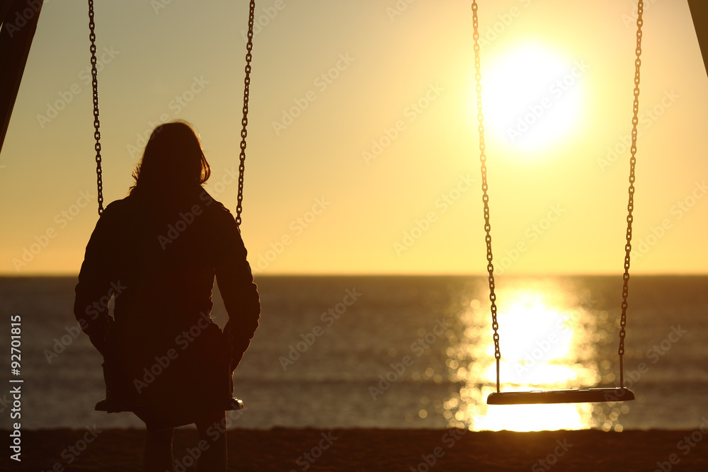 Lonely woman watching sunset alone in winter - obrazy, fototapety, plakaty 